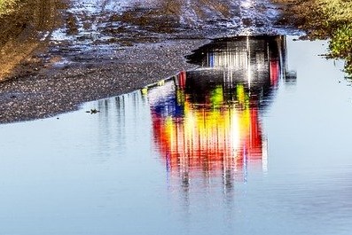 Emergency vehicles reflected in a puddle of water